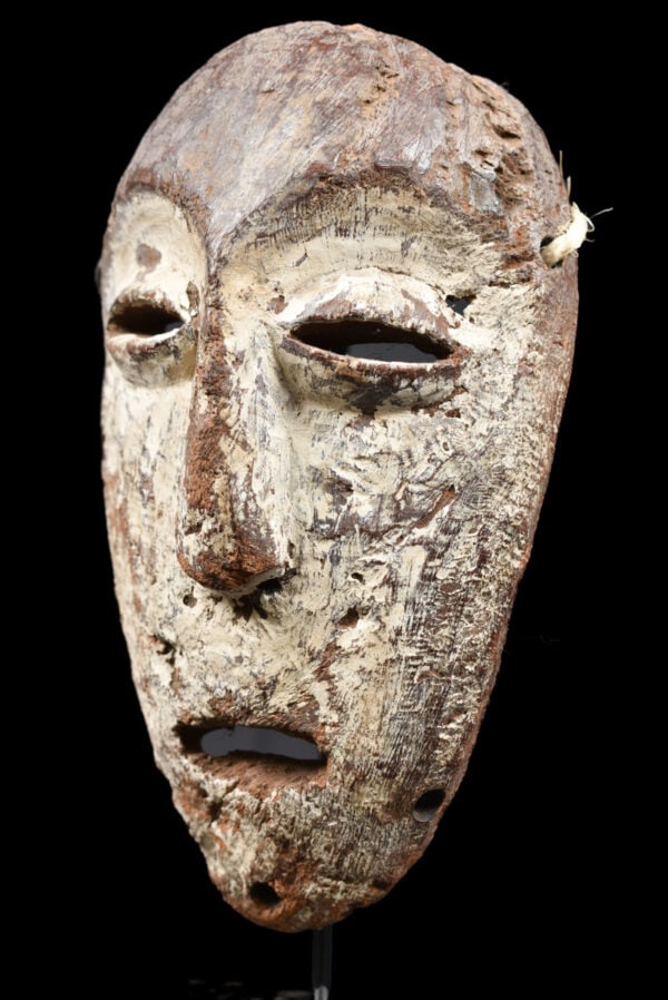 Mask – Wood – Lega – Congo: Lega Mask from Zaire / DR Congo. Wood with multi-layered patina. Remains of offerings, mica powder, kaolin. Condition: good with a beautiful aged patina due to tribal use. Covered in Pembe, white clay