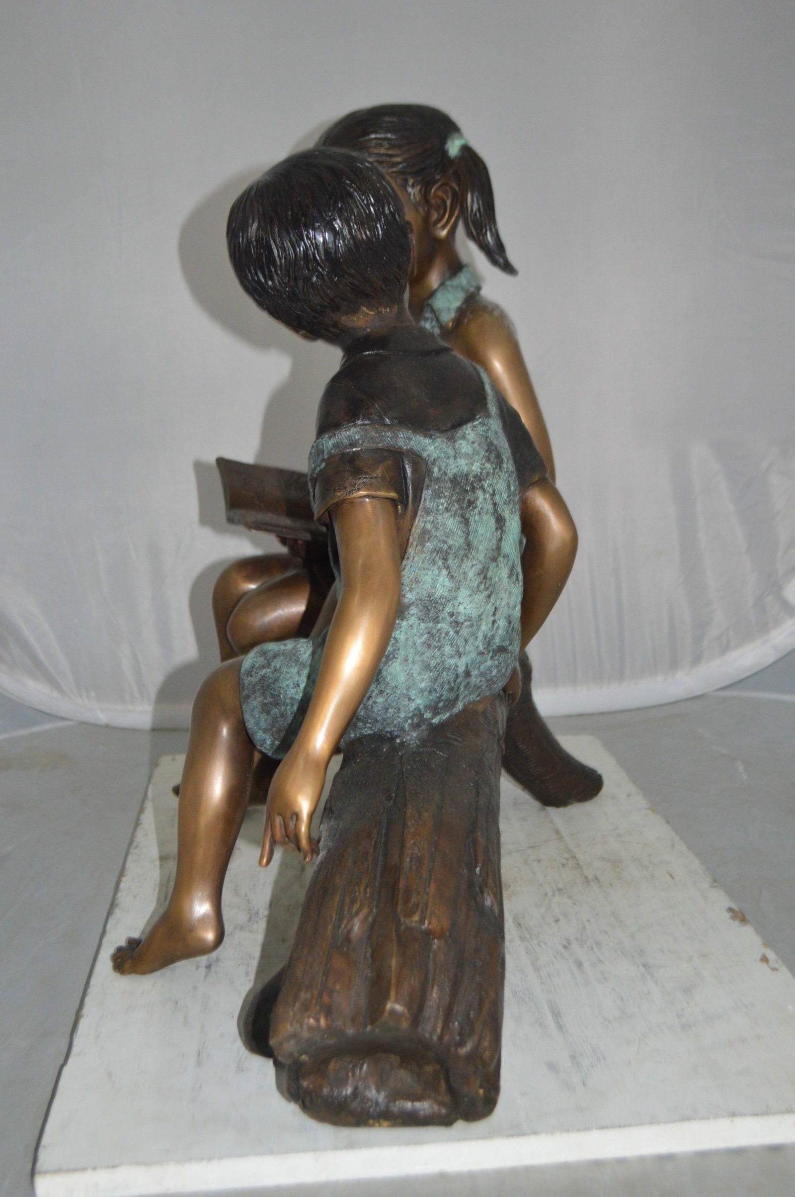 Boy and Girl on a tree log reading Bronze Statue - Size: 37"L x 14"W x 27"H. - 11