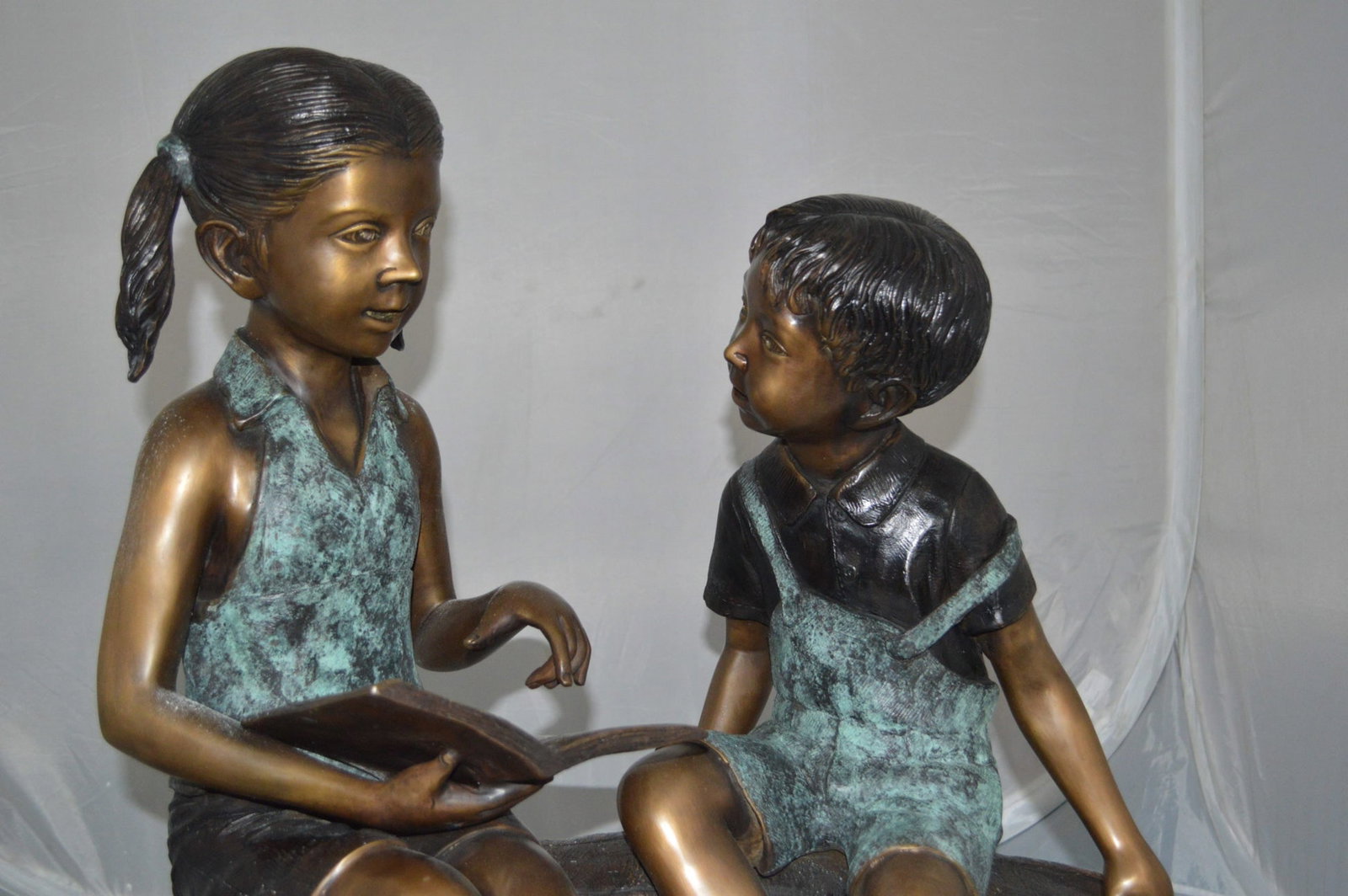 Boy and Girl on a tree log reading Bronze Statue - Size: 37"L x 14"W x 27"H. - 13