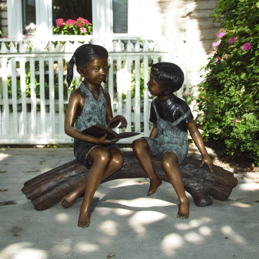 Boy and Girl on a tree log reading Bronze Statue - Size: 37"L x 14"W x 27"H. - 3