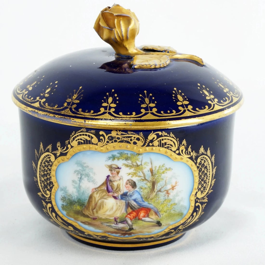 Antique German Cobalt Blue Covered Jar Courting Couple: Title:Antique German Cobalt Blue Covered Jar Courting Couple Size:3 ¾ in (9.5 cm) diameter x 4 ¼ in (10.8 cm) tall). Description:A beautifully hand-painted rococo-style porcelain