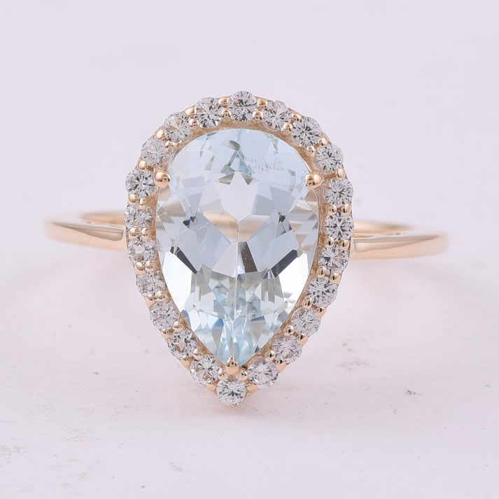 3.15 Ct Pear Aquamarine 9K Gold Ring: 3.15 Total Carat Aquamarine 9K Gold Ring Specifications: Total Weight 2.435 g Center Gemstone Aquamarine Gemstone Carat Weight 2.75 Carats Gemstone Measurements 11.90X8X5.60 mm Additional Gemstones