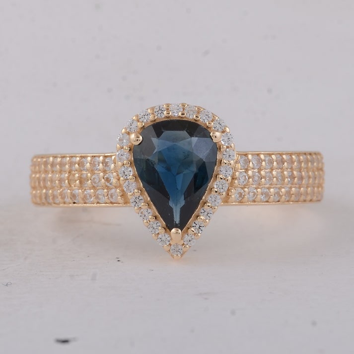 1.23 Ct Pear Sapphire 9K Gold Ring: 1.23 Total Carat Sapphire 9K Gold Ring Specifications: Total Weight 2.45 g Center Gemstone Sapphire Gemstone Carat Weight 0.88 Carats Gemstone Measurements 8X5.80X2.60 mm Additional Gemstones White