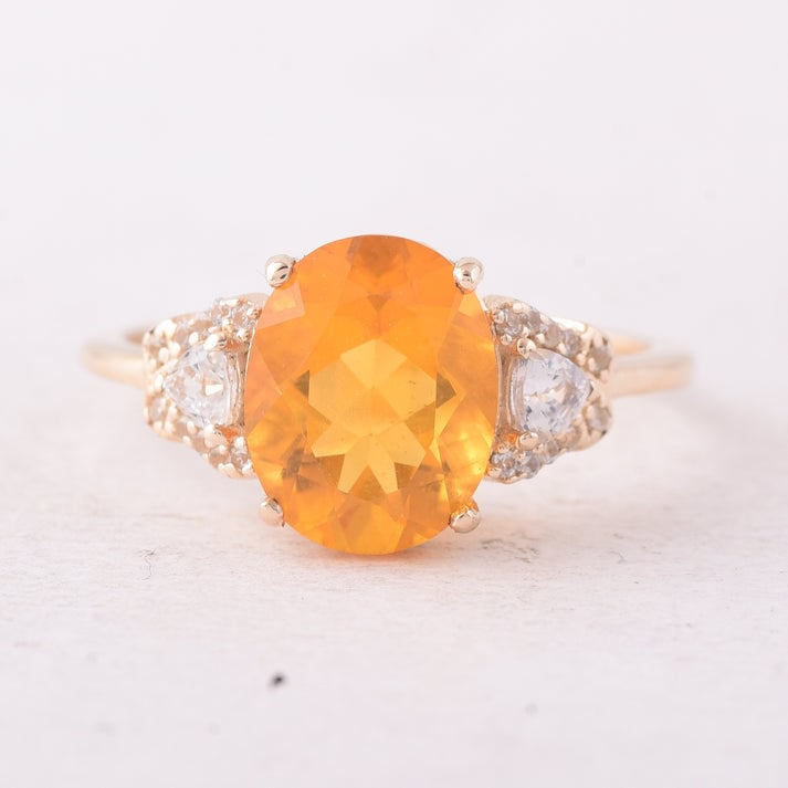 2.09 Ct Oval Fire Opal 9K Gold Ring: 2.09 Total Carat Fire Opal 9K Gold Ring Specifications: Total Weight 2.312 g Center Gemstone Fire Opal Gemstone Carat Weight 1.76 Carats Gemstone Measurements 10.20X8.10X5.50 mm Additional Gemstones