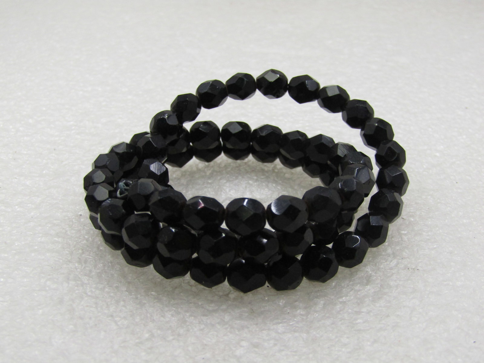 Vintage Black Faceted Glass Coiled Bracelet, Up to 7.5": Vintage Black Faceted Glass Coiled Bracelet, Up to 7.5". Mid-Century black faceted beaded coiled bracelet that is 6" at rest but can be wrapped to fit up to a 7.5 wrist. The beads are appx. 6.5mm wide