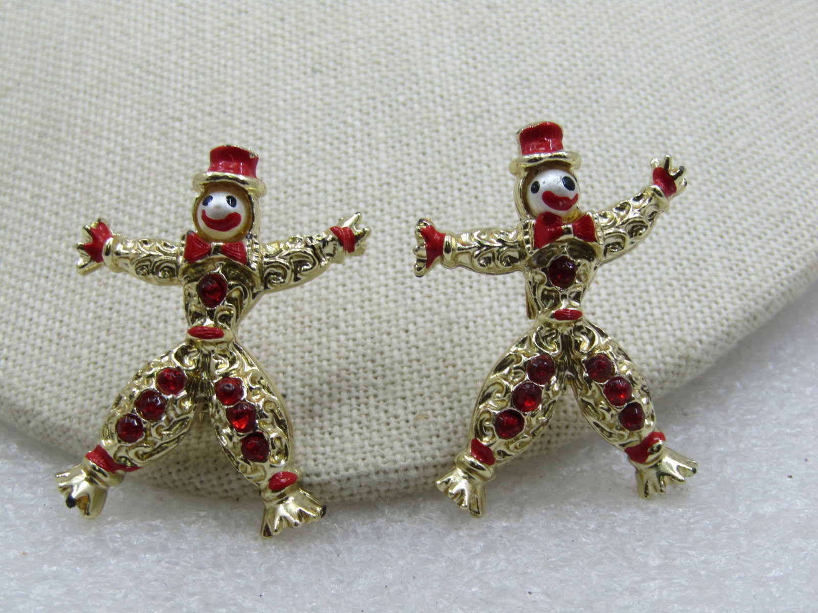 Vintage Pair Dancing Clown Brooches with Rhinestones & Enameling, 1950's-1960's: Vintage Pair Dancing Clown Brooches with Rhinestones & Enameling, 1950's-1960's. Gold tone and 1.5" tall and 1.25" wide with their arms and legs widely spread. Red rhinestones are set up their legs wi