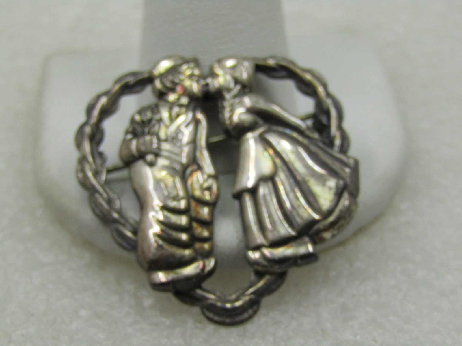 Vintage Sterling Kissing Dutch Girl/Boy Heart Brooch, 1940's: Vintage Sterling Kissing Dutch Girl/Boy Heart Brooch, 1940's. Hart frame with ridged and smooth accents frame this brooch with a Dutch boy and girl leaning toward each other and kissing. It is appx.