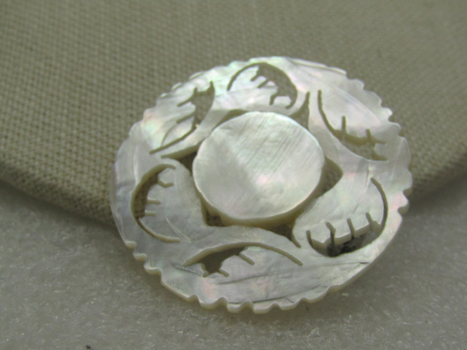 Vintage Carved Mother-of-Pearl Floral Brooch, Signed Bethlehem: Vintage Carved Mother-of-Pearl Floral Brooch, Signed Bethlehem. A couvenir brooch from Bethlehem - floral, leaf carved design, 1.75" circle with scalloped edge and cut-out work. Very good condition. A