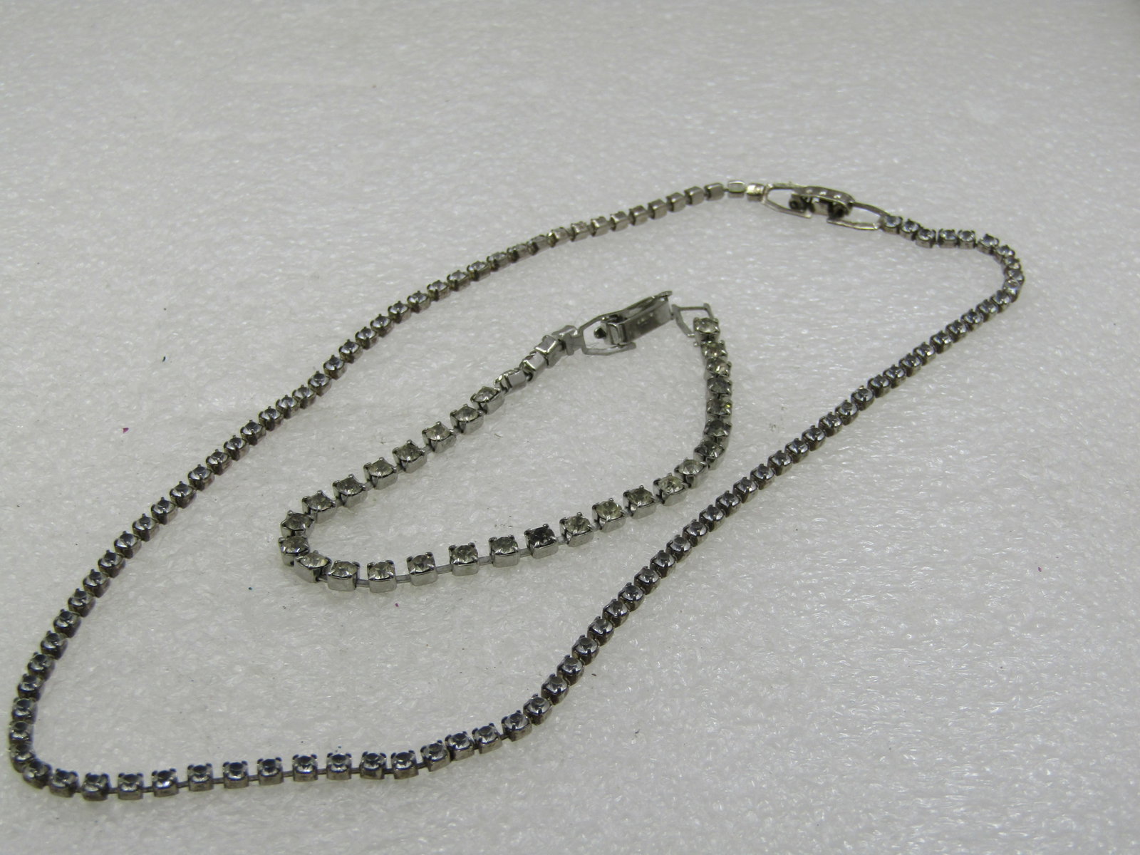 Vintage Rhinestone Chain Necklace & Bracelet Set, 15" and 7": Vintage Rhinestone Chain Necklace & Bracelet Set, 15" and 7". It is a single strand. the necklace is 2mm wide and the bracelet is 3.5mm wide. Both have flip clasps. Silver tone. Age is appx.