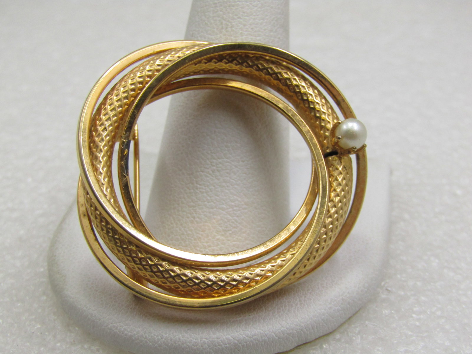 Vintage Intertwined Circle Brooch, Faux Pearl, 1.75", 1960's-1970's: Vintage Intertwined Circle Brooch, Faux Pearl, 1.75", 1960's-1970's. Gold tone with a wider mesh circle and three smothh squared tubular circles with a single 4mm prong-set pearl. It is not signed by 