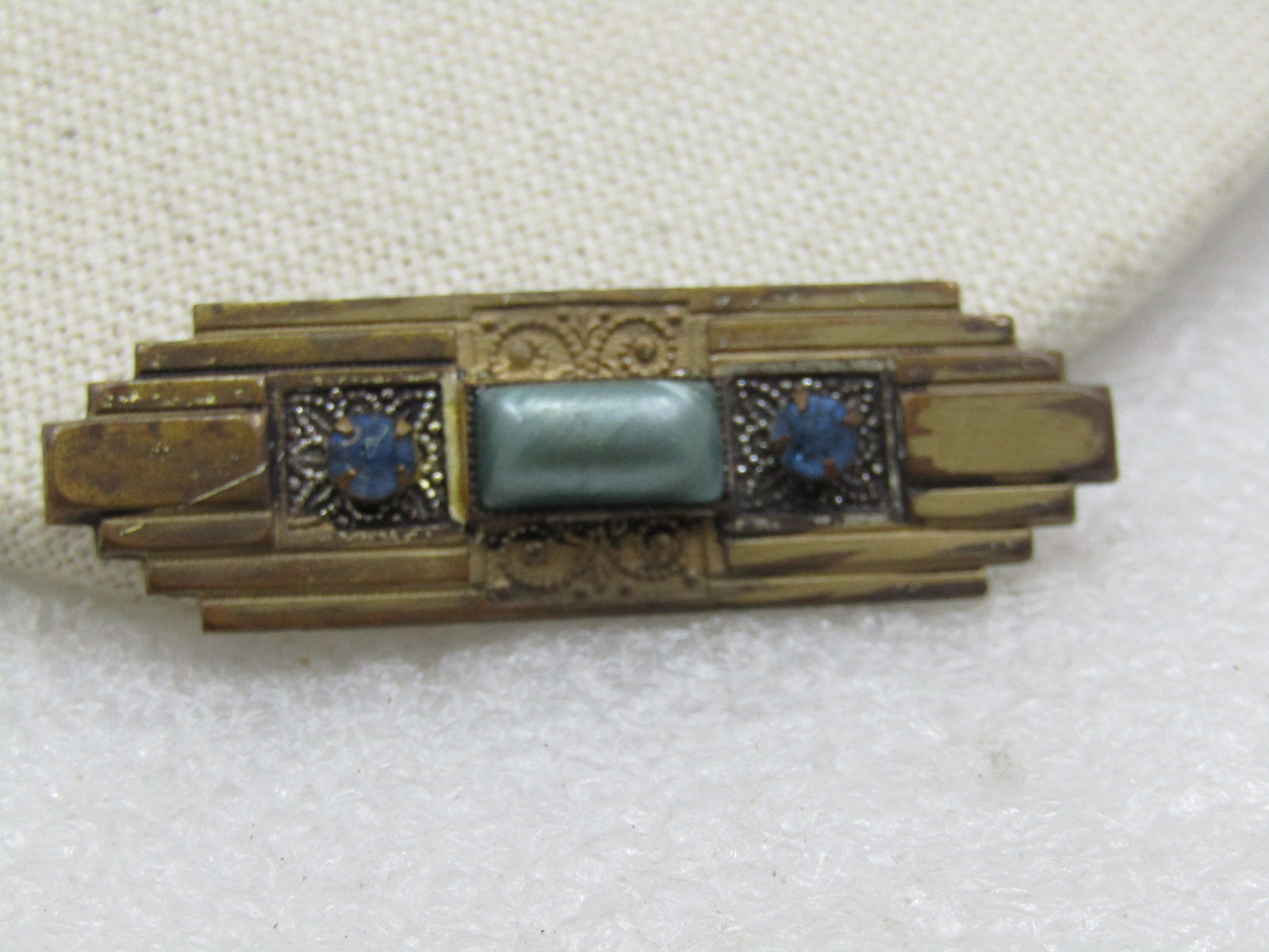 Antique Art Deco Brooch, Rhinestones , C-Clasp, 1910-1920's: Antique Art Deco Brooch, Rhinestones , C-Clasp, 1910-1920's. It has a ridged design with recessed scrolled designs with appx. 4mm wide blue rhinestones - one on each side. In the center is a raised te