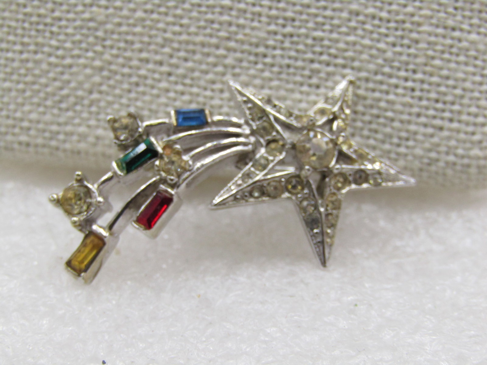 Vintage Shooting Star Rhinestone Brooch, 1940's-1950's, 1.5": Vintage Shooting Star Rhinestone Brooch, 1940's-1950's, 1.5" by 3/4". Sivler tone with clear rhinestones in the star and red, yellow, blue baguettes in the trails with round clear stones. Not signed b