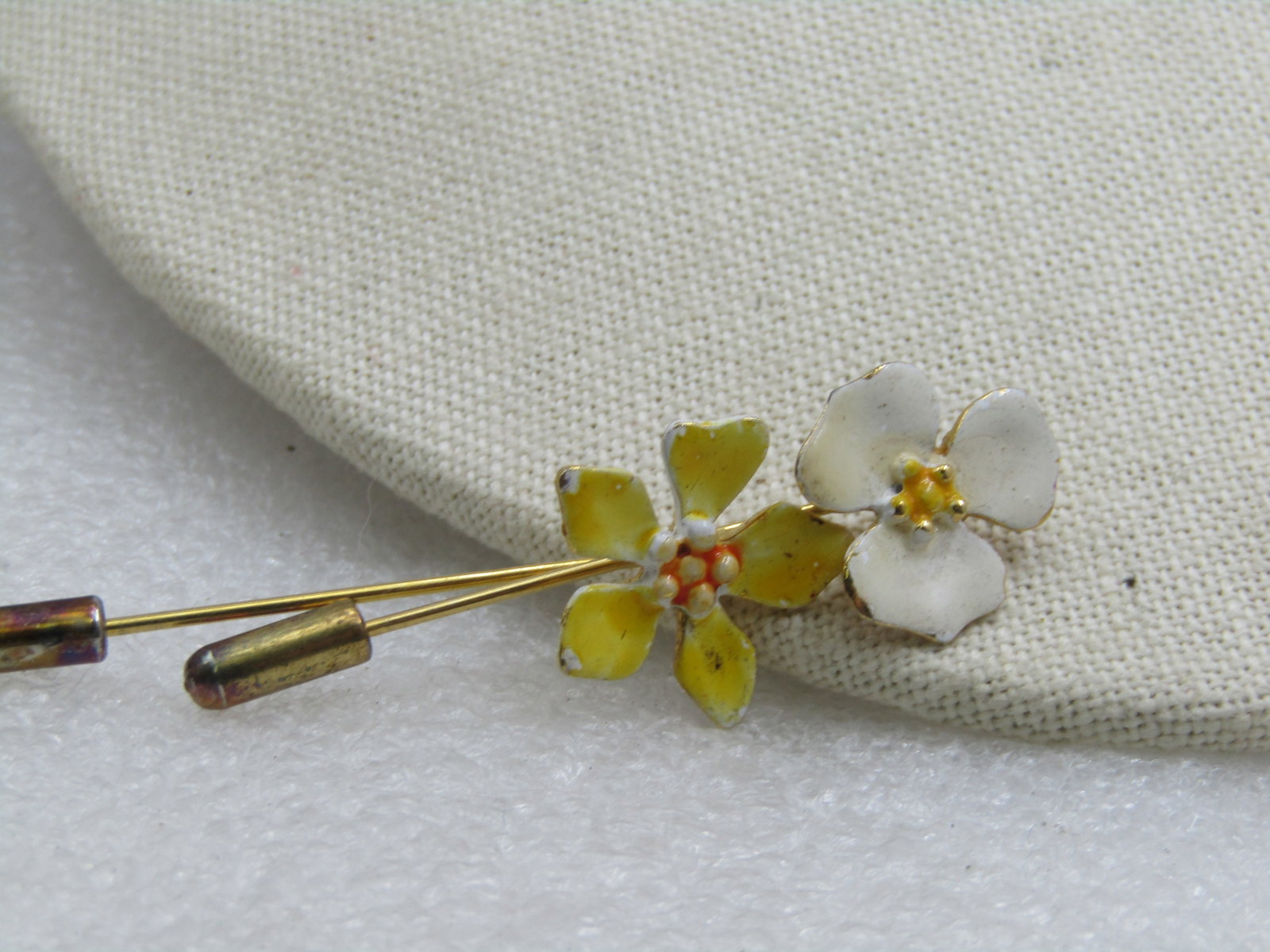 Vintage Pair of Enameled Floral Stick Pins, 1960's: Vintage Pair of Enameled Floral Stick Pins, 1960's. One blossis is yellow ith an ornage center and the other white with a yellow center. Safety caps included. Appx. 2/25" long with the blossoms being 