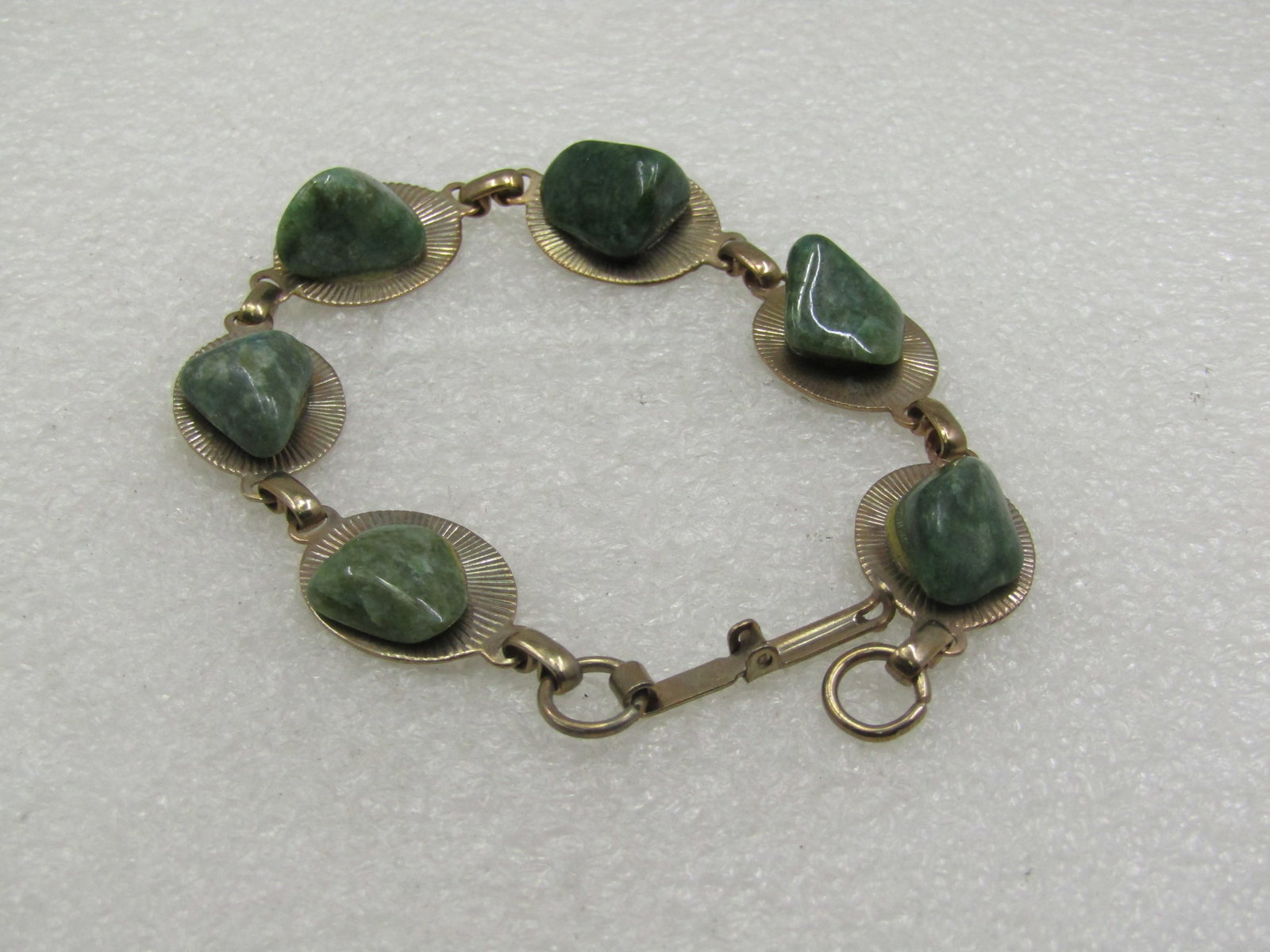 Vintage Green Agate Link Bracelet, 7.75.", 1960's.: Vintage Green Agate Link Bracelet, 7.75.", 1960's.. There is a polished nugget, all slightly different in size attached by jeweler's cement on each ridged oval link of the bracelet. The base of the li