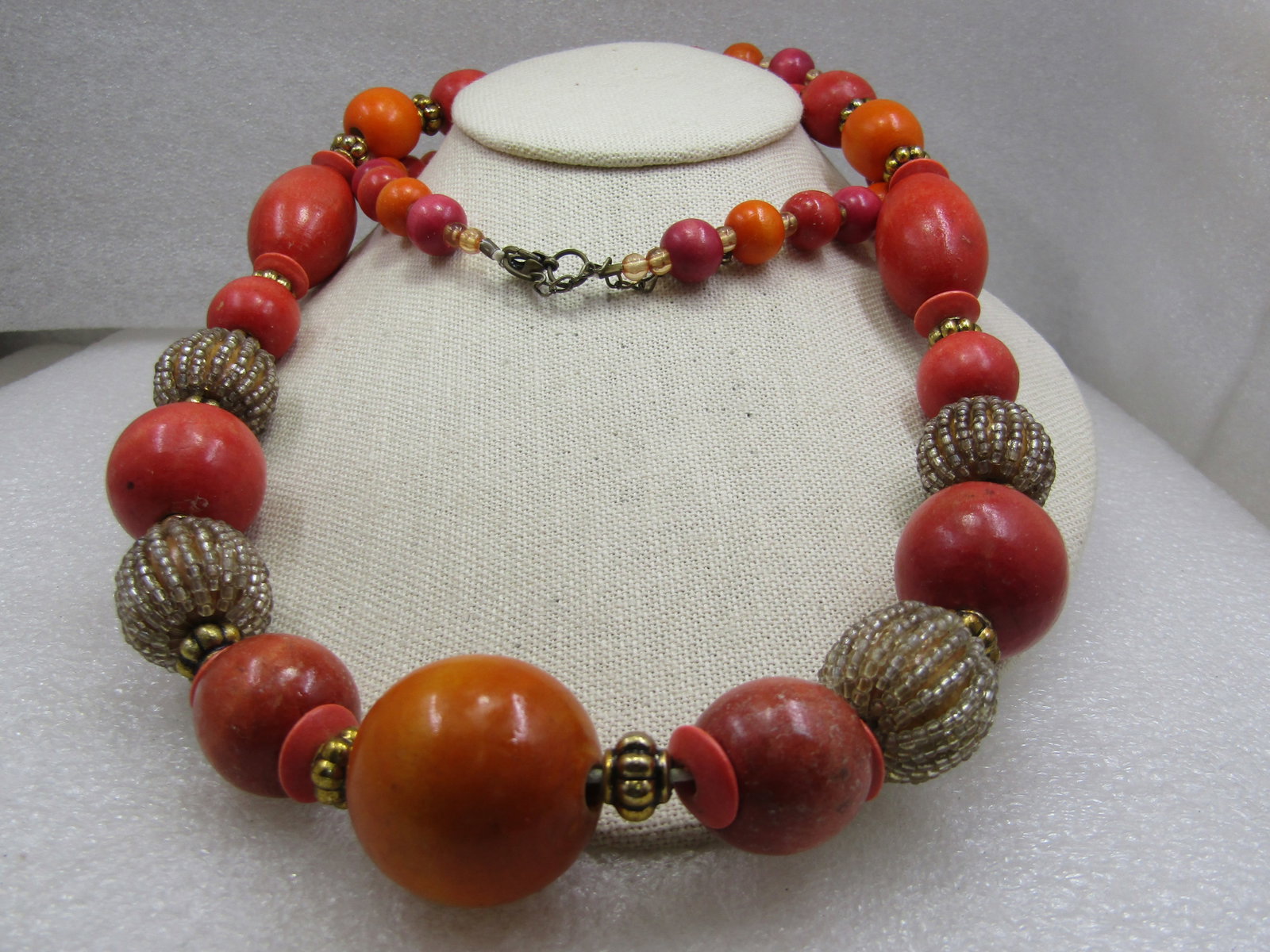 Vintage Orange, Gold, Clear Beaded Necklace, 36", 1980's: Vintage Orange, Gold, Clear Beaded Necklace, 36", 1980's. Wooden shades of orange beaded necklce in graduated round beads with oblogn beads as well from 11mm to 28mm. Between some of these beads are g