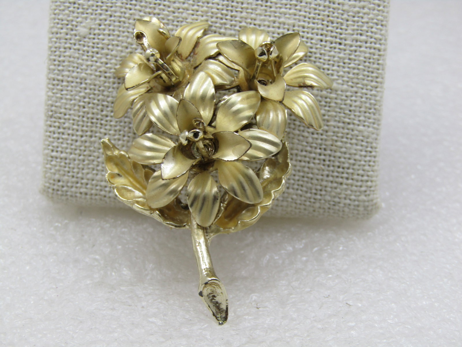 Vintage Gold tone Lily Blossom Brooch, 1960's, 2.25": Vintage Gold tone Lily Blossom Brooch, 1960's, 2.25" tall by 1.5" wide. Satiny gold tone finish on the blossom, smooth and shiny stem. There are two leaves beneath the bottom flower blossom peaking