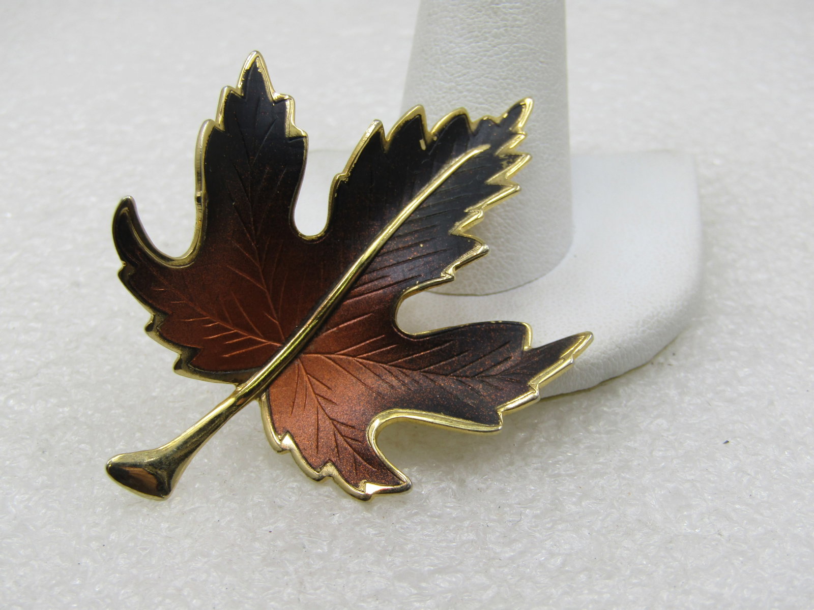 Vintage Enameled Black and Copper Leaf Brooch, 1960's, 2.5": Vintage Enameled Black and Copper Leaf Brooch, 1960's, 2.5" tall and 1.75" wide. Gold tone stem and edges of the brooch and undercarriage. The brooch is curved with a lower center and higher on the ed