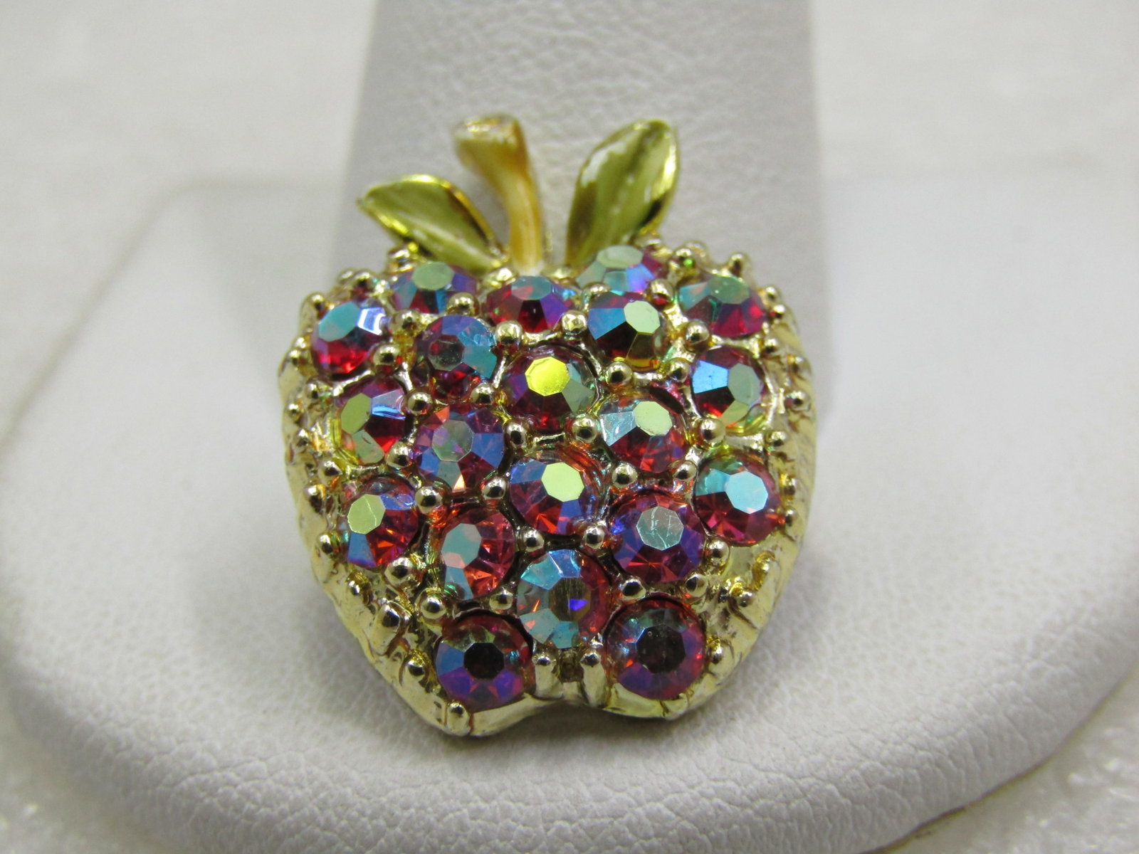 Vintage Red Aurora Borealis Rhinestone Apple Brooch, 1": Vintage Red Aurora Borealis Rhinestone Apple Brooch, 1" by 3/4". . Textured apple in gold tone metal with enameled pale green leaves and a tan stem. Age is appx. 1960's. Not signed by the maker. Very