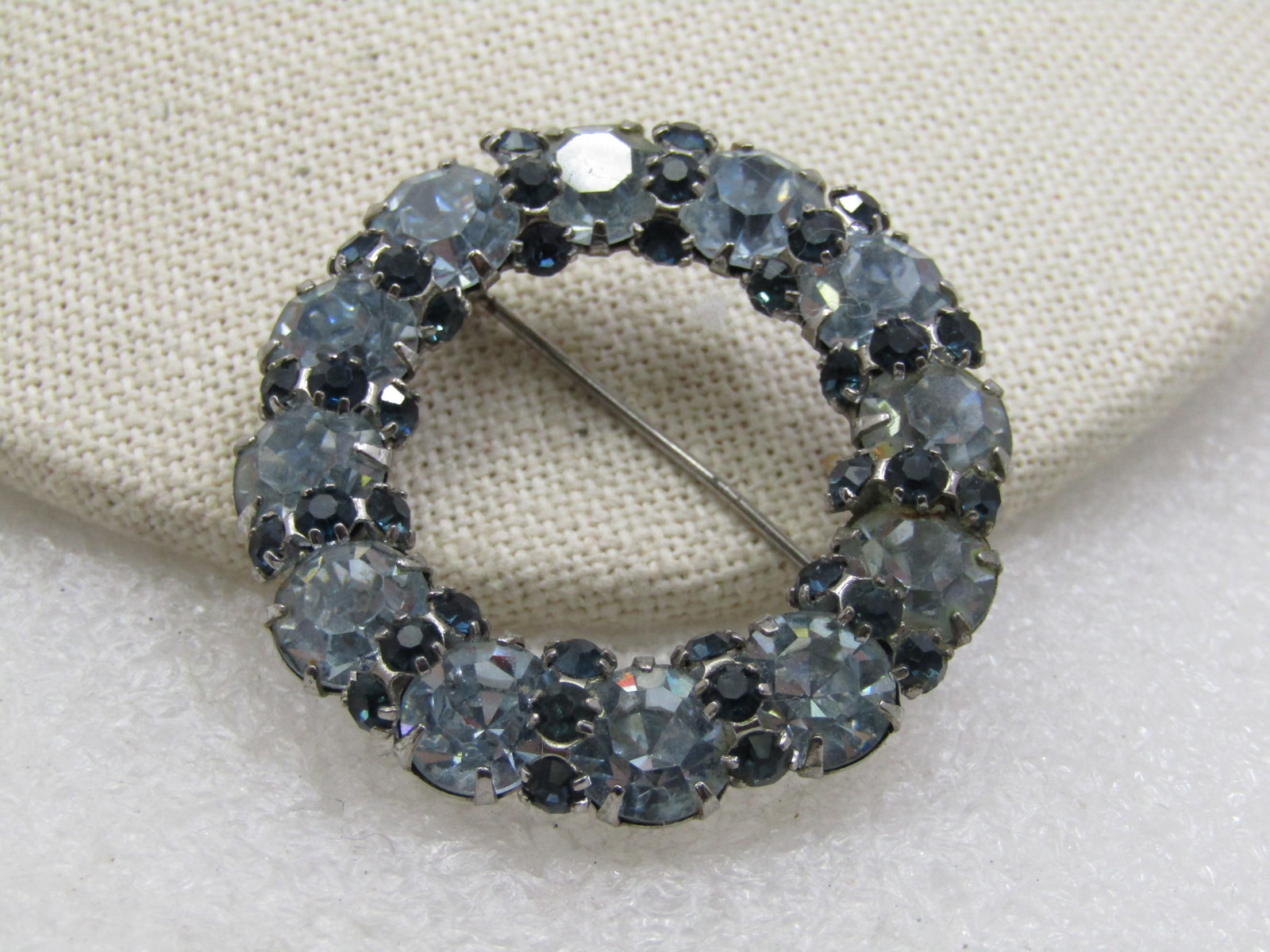 Vintage Blue Rhinestone Circle Brooch, 1.75", 1940's: Vintage Blue Rhinestone Circle Brooch, 1.75", 1940's. Pale blue 8mm round stones areound the circle with a vertical row of three dark blue 2mm round rhinestones between each larger pale blue