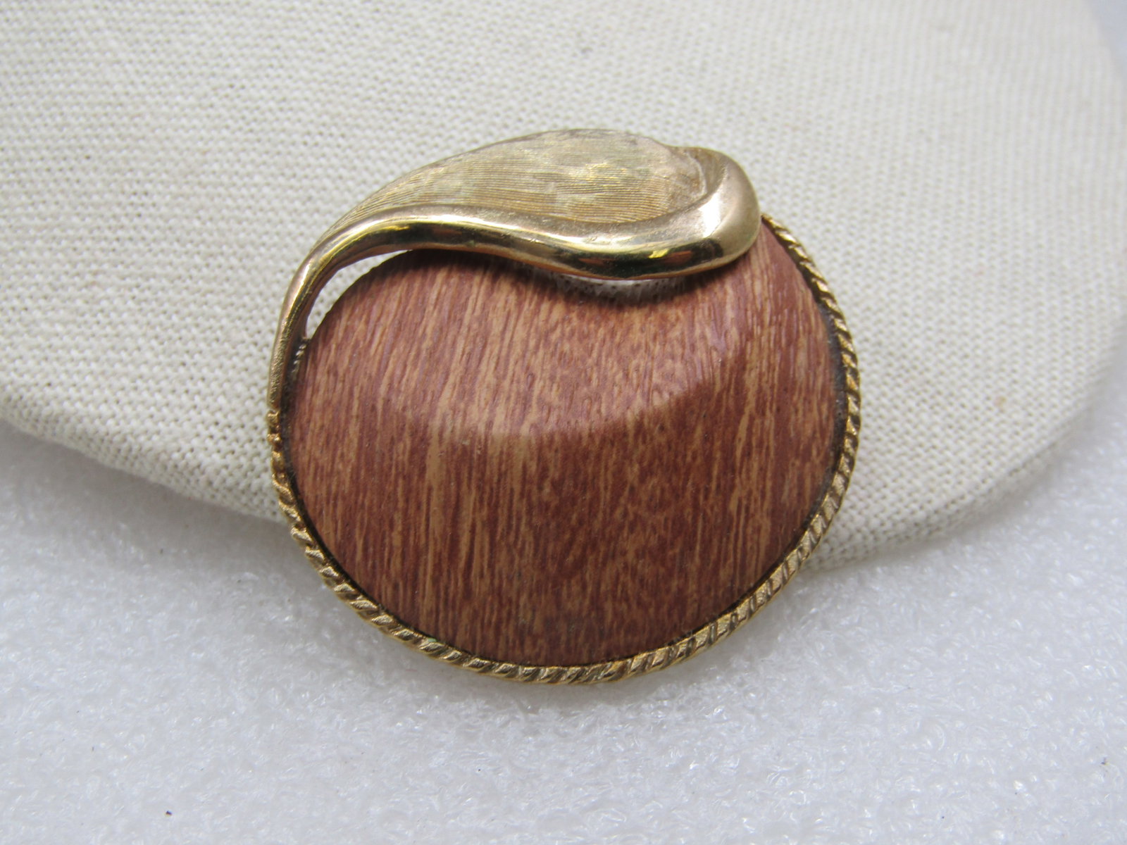 Vintage 1960's Mod Wood & Gold Circle Brooch, 1.75": Vintage 1960's Mod Wood & Gold Circle Brooch, 1.75". This has a textured and smooth leaf accent with gold tone rope frame and a center that is wood, possibly teak, with a domed and ridged design. It