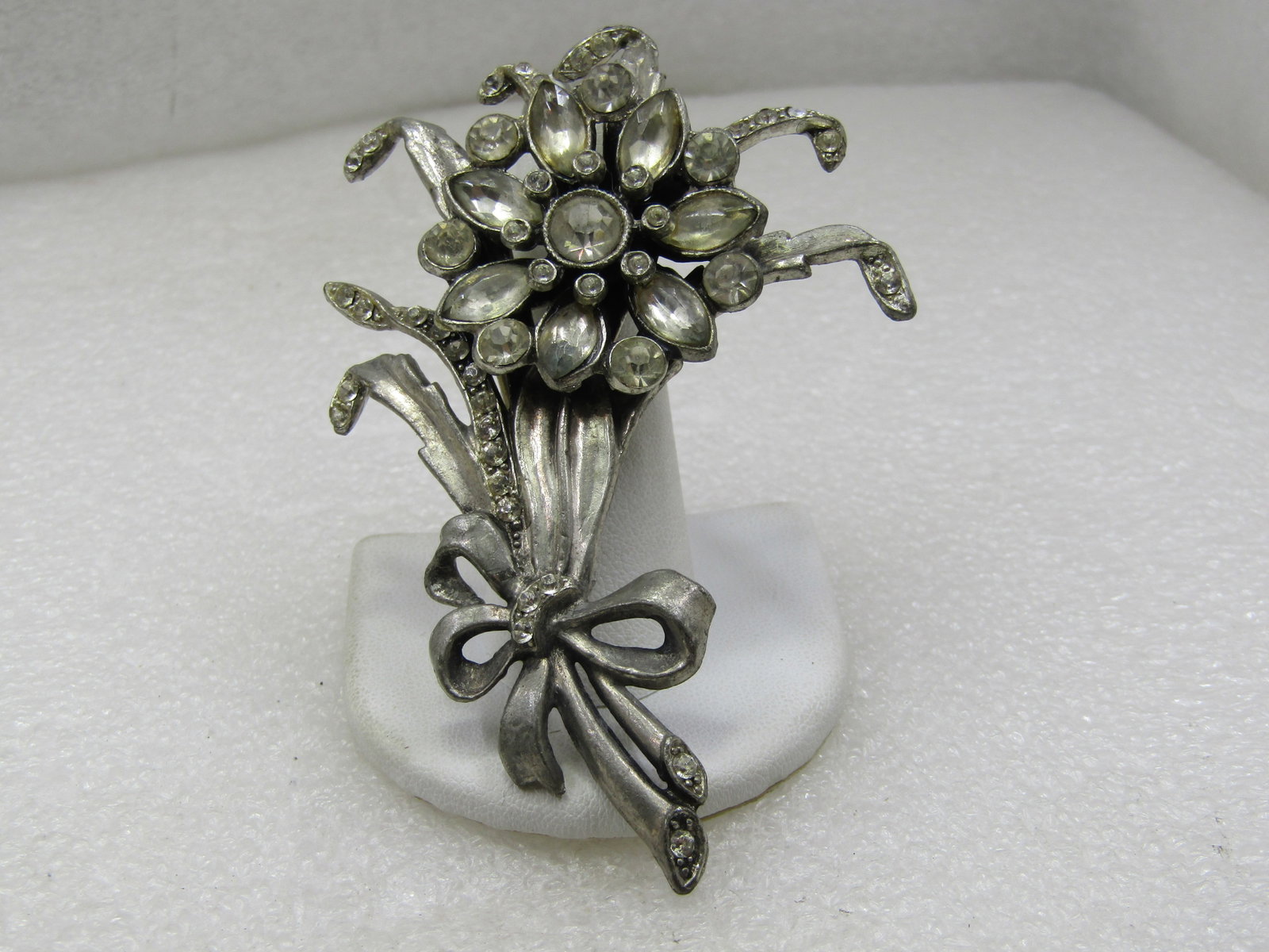 Vintage Rhinestone Bouquet Tall Brooch, 1930's, 3.75": Vintage Rhinestone Bouquet Tall Brooch, 1930's, 3.75" by 2.25". Pot metal in silver tone with a raised rhienstone blosson set on top with marquise and round stones that is appx. 1-3/8" wide. There are