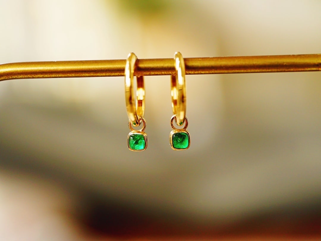 18K gold emerald earrings: Title: 18K gold emerald earrings Description: These earrings are meticulously set in 18K gold, with each emerald carefully selected to showcase rich color and high clarity. Their versatile design