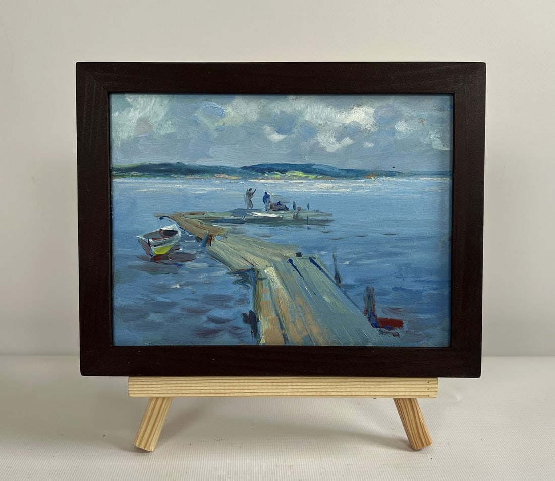Oil painting Fishing on the ferry Yuriy Suprunchuk: NoAAA4409The painting "Fishing on the Ferry" masterfully captures a tranquil moment by the water, where a group of figures stands and sits on a wooden pier extending into the vast blue expanse. The