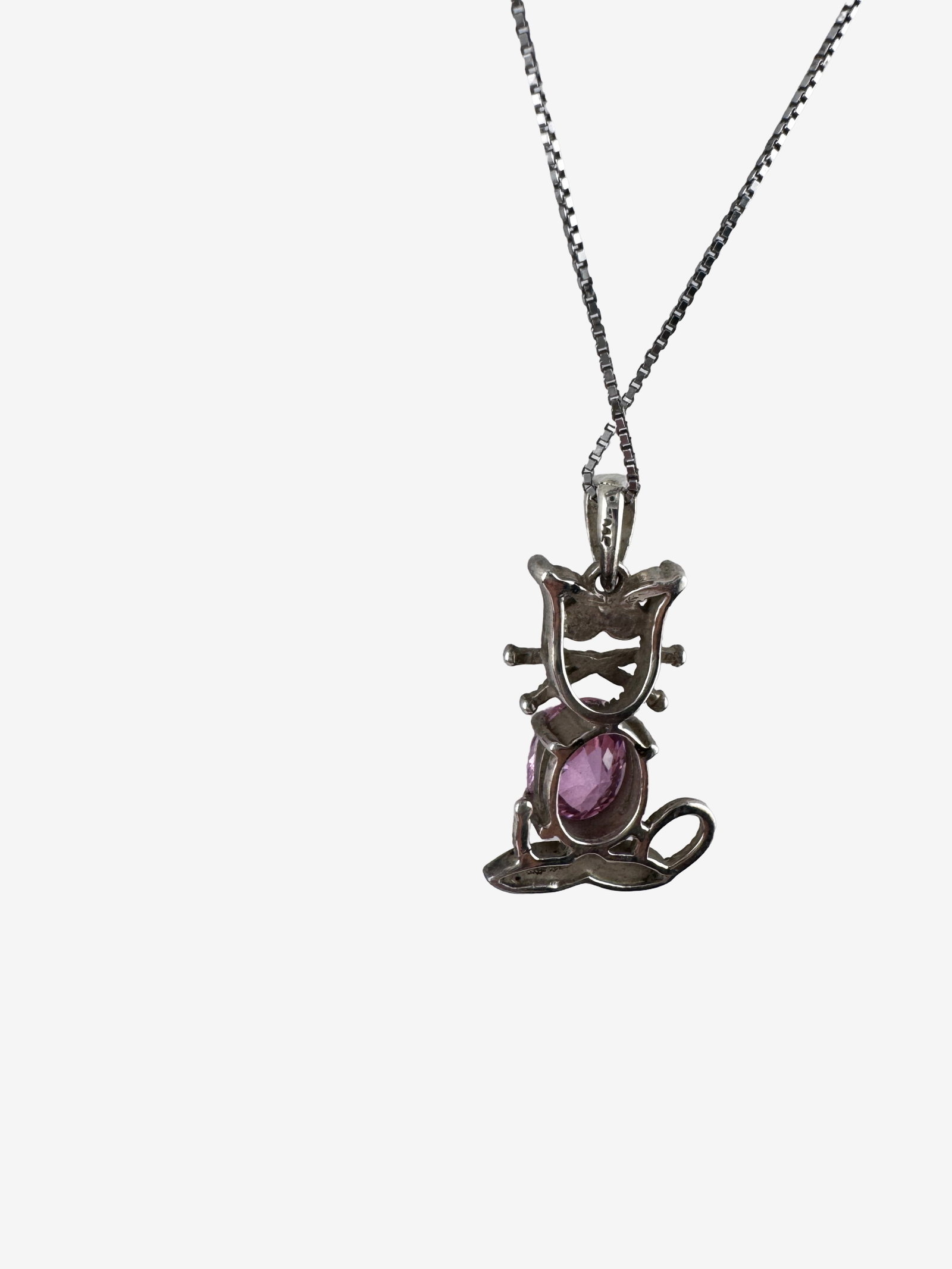 Vintage Sterling Silver Necklace and Pendant Set: A charming sterling silver necklace featuring a cat-shaped pendant. The cat's body is adorned with a prominent oval-cut pink gemstone, and smaller marcasite stones detail its head and tail, adding a s