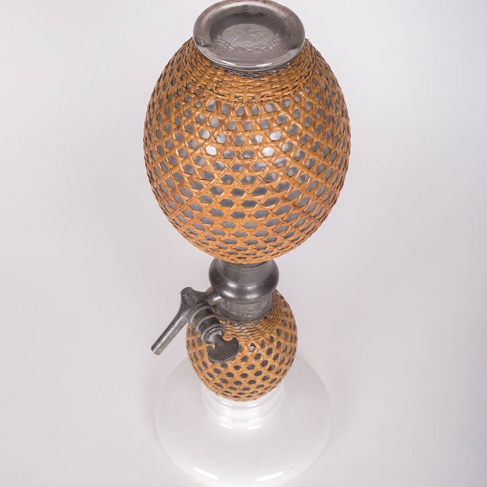 19th Century French Seltzer Siphon ceramic base: Decorative glassware with its hourglass figure and signed pewter pump. This syphon feature a split cane covering c1880-1910.; H.19 in , I can be reach at the 310 994 6009 if you want more info , for s