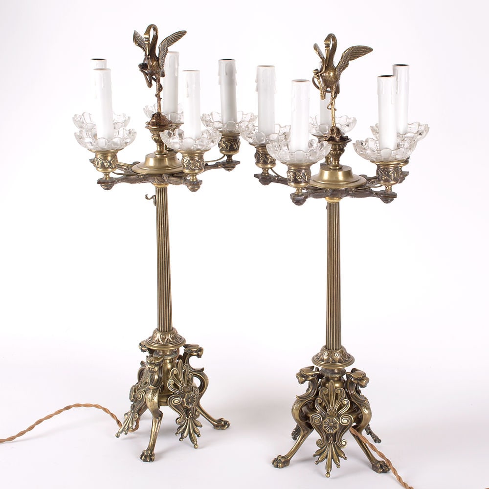Important pair of French Restauration candelabra in gilt bronze,: Important pair of Restauration-style candelabra in gilt bronze, featuring a tripod base with claw feet and griffin heads. The columnar shaft is decorated with recessed fluting. They are fitted with fi