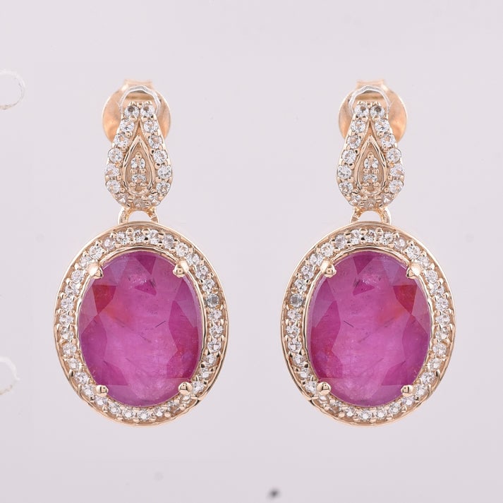 6.89 Ct Oval Ruby 9K Gold Earrings: 6.89 Total Carat Ruby 9K Gold Earrings Specifications: Total Weight 3.42 g Center Gemstone Ruby Gemstone Carat Weight 6.47 Carats Gemstone Measurements 10X8 mm Additional Gemstones White Sapphire Addi