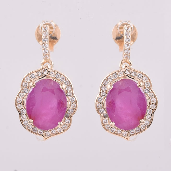 4.33 Ct Oval Ruby 9K Gold Earrings: 4.33 Total Carat Ruby 9K Gold Earrings Specifications: Total Weight 2.863 g Center Gemstone Ruby Gemstone Carat Weight 4.02 Carats Gemstone Measurements 9X7 mm Additional Gemstones White Sapphire Addi