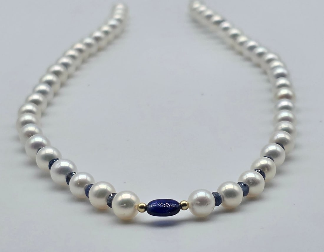 Akoya pearl necklace, 6.2 to 6.4 mm, with natural sapphire spacers, a central oval sapphire with: Title:Akoya pearl necklace, 6.2 to 6.4 mm, with natural sapphire spacers, a central oval sapphire with spheres and an 18kt (750) gold clasp Description:Akoya pearl necklace, 6.2 to 6.4 mm, with