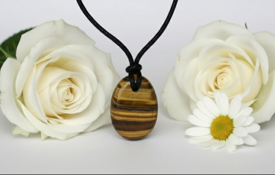 Tiger Eye Oval Pendant With Adjustable Black Cord: Title:Tiger Eye Oval Pendant With Adjustable Black Cord Description:Pendant DetailDesign : Oval Pendant With Adjustable Black Cord Stone Name : Tiger EyeColor : BrownMeasurment : 18x25 MMShape : Oval,