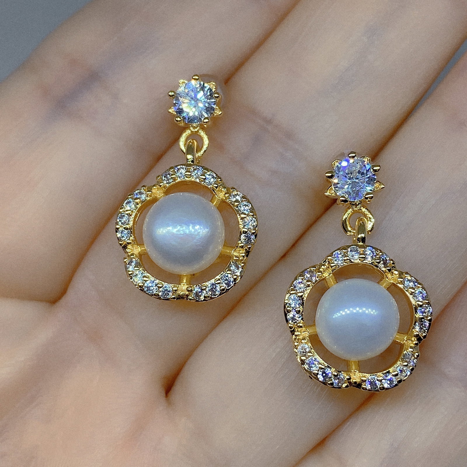 Cultured Pearls Flower Designed Earrings: Title: Cultured Pearls Flower Designed Earrings Description:Cultured Pearls Flower Designed Earrings The earrings are made of 18k gold plated silver inlaid with light blue Moissanite and genuine white