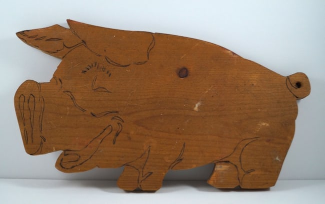 Antique Wooden Pig Cutting Board: Title: Antique Wooden Pig Cutting Board Additional Information: Antique wooden Pig Cutting Board with eye-appealing pyrography cut out. Showing cutout in form of a pig with curled tail, eye, ears,