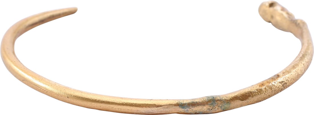 VIKING SERPENT BRACELET, 8TH-10TH CENTURY AD: Gilt bronze, C form with an abstracted snake or sea serpent head and tapered tail. About 2 1/2” (2.47”) inner dimension for an average arm. Surface texture from burial. Professionally
