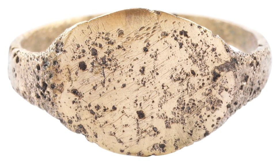 ROMAN/BYZANTINE RING C.5TH-8TH CENTURY AD, SIZE 6 ½: Gilt bronze, size 6 ½ with 2.2mm rounded face band flaring to the shoulders. Oval bezel textured in a pattern, possibly remnants of ciphers suggesting that it was the ring of a sorcerers,