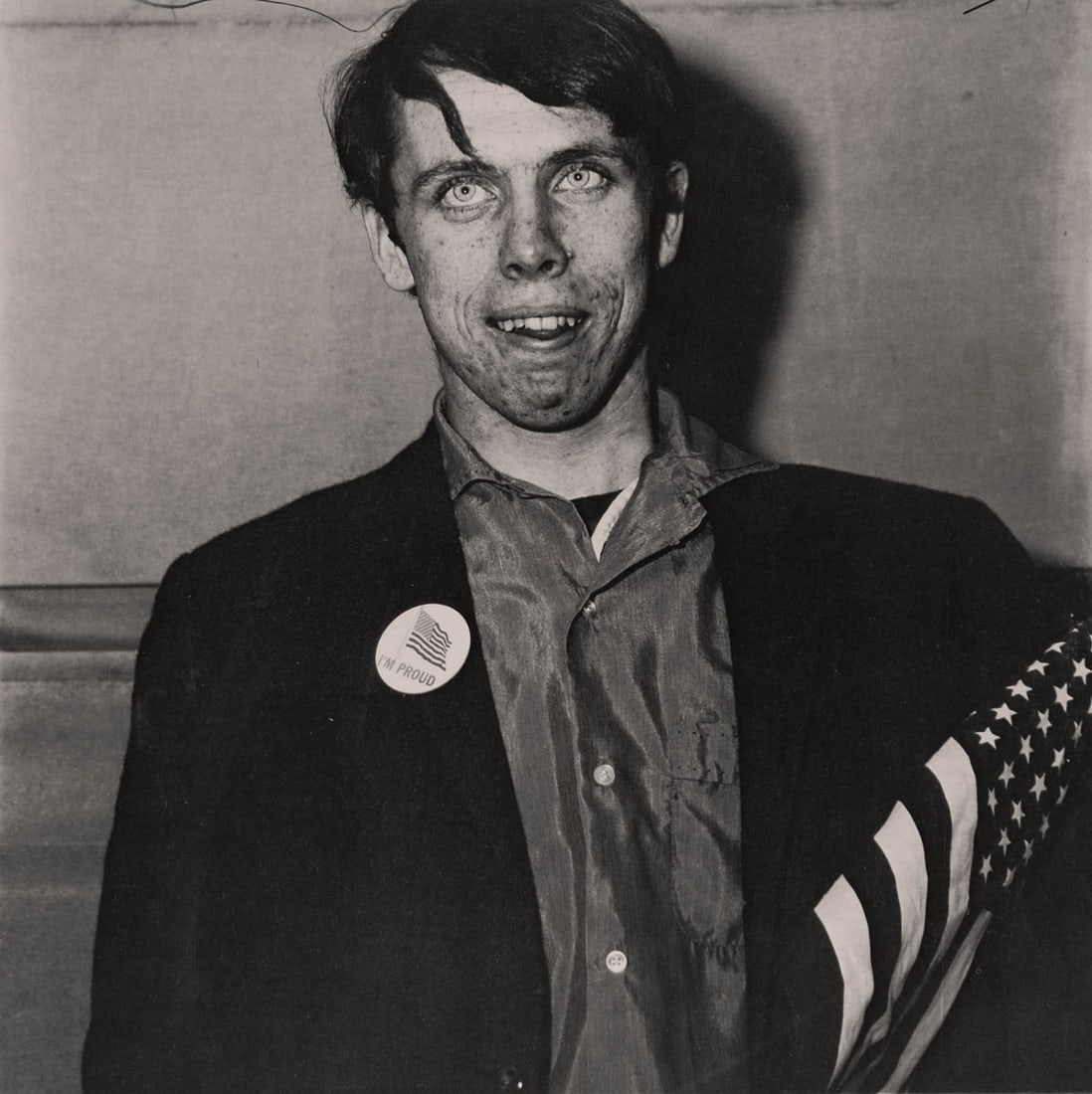 DIANE ARBUS - Patriotic young man with a flag, NYC, 1967: Artist: DIANE ARBUS Print Title: Patriotic young man with a flag, NYC, 1967 Medium: Duotone Print Printed 2000s in Germany Image size (inches) approx. 8 x 8” Diane Arbus (1923 –1971),was