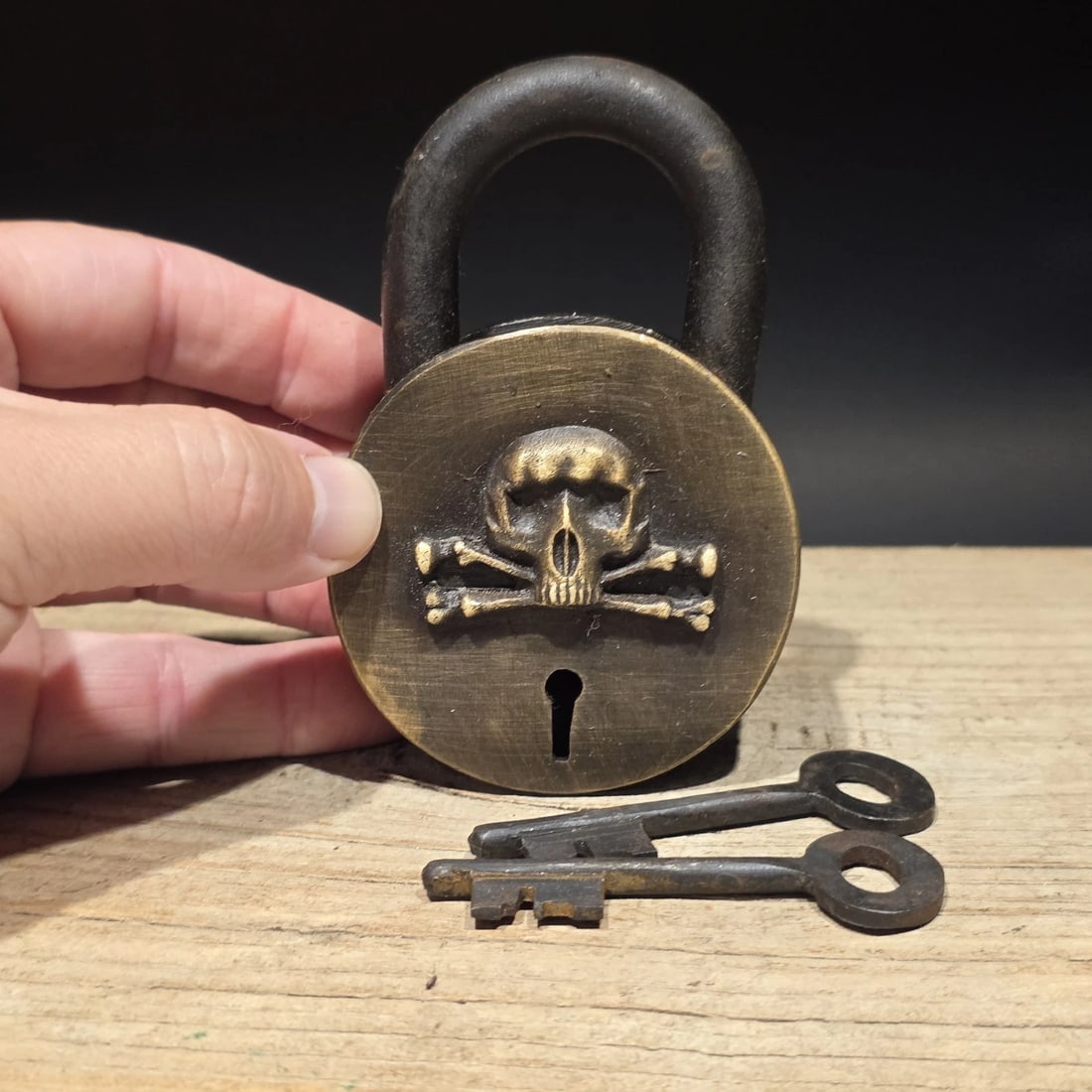 Wrought Iron & Brass Pirate Skull Crossbones Bridge Padlock Lock: Reproduction functional decorative padlock featuring a raised skull and crossbones emblem, styled after traditional pirate and maritime imagery. Symbols like the skull and crossbones became closely as