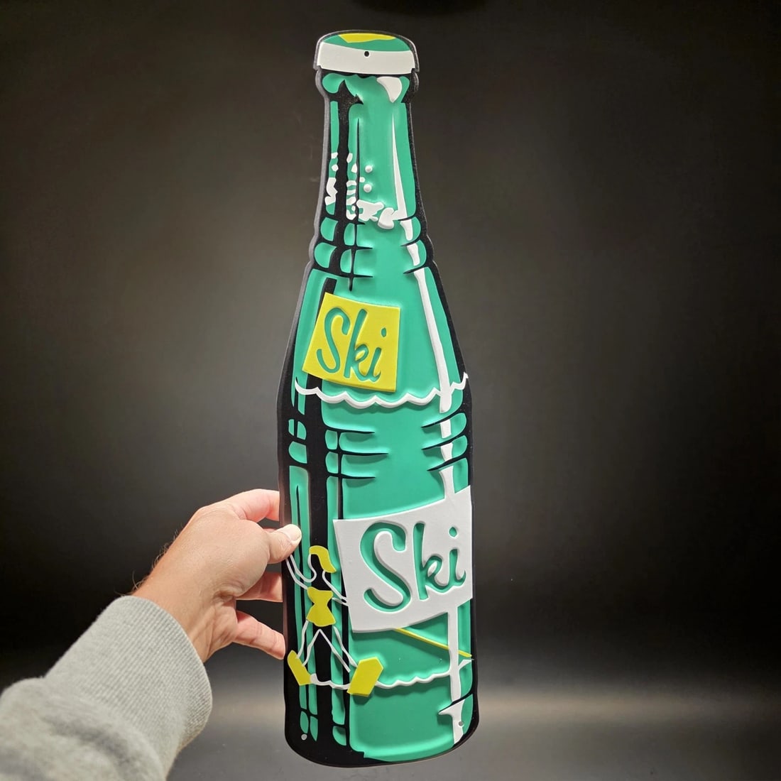 22" Ski Soda Advertising Metal Wall Sign: 22" Long x 6" Vintage-Style Ski Soda Glass Bottle Metal Wall Sign Add a refreshing pop of color to your space! This vibrant metal wall sign is shaped like the classic, iconic glass Ski bottle,