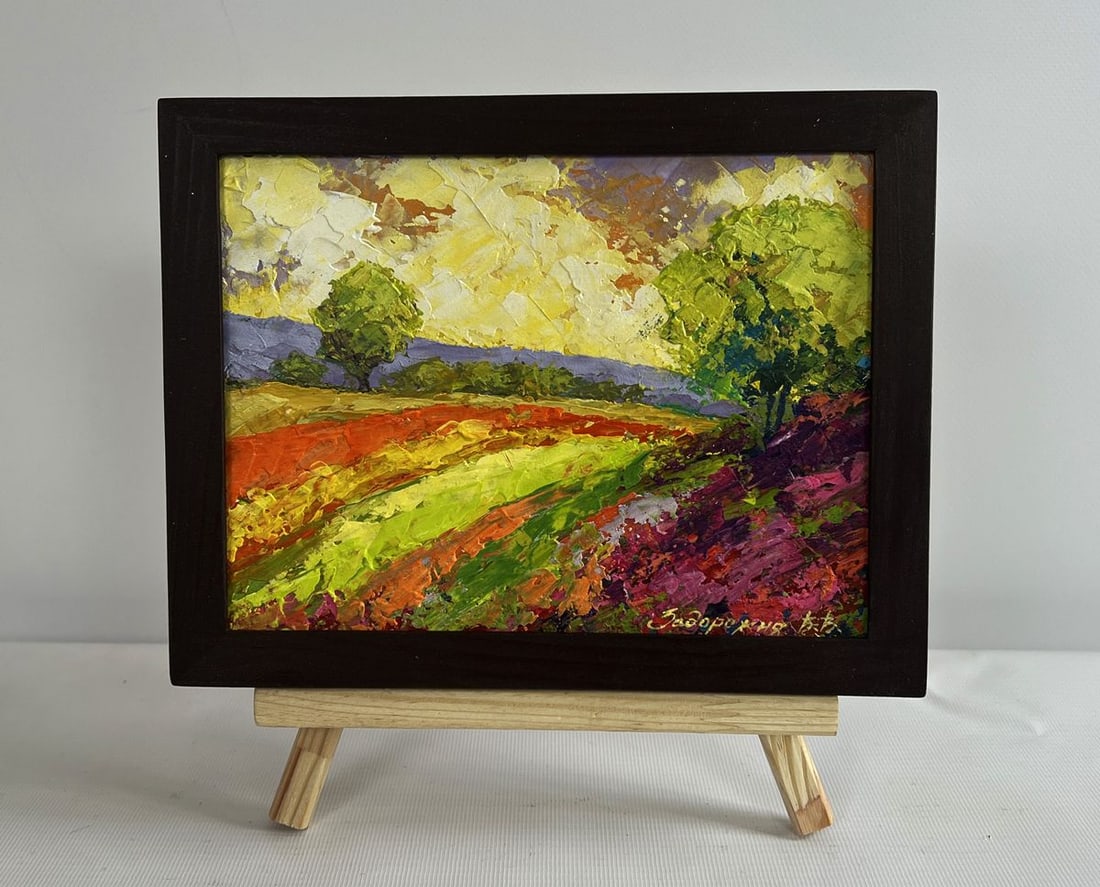 Oil painting Flower meadows in the rays of sunset V. Zadorozhnya: NoAAA4617The oil painting on cardboard titled "Flower Meadows in the Rays of Sunset" is a vibrant and expressive depiction of nature's beauty as the day transitions into evening. The artist employs