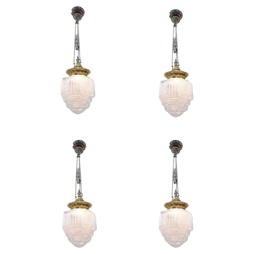 Art Deco Brass Ceiling Pendant w/ Stepped Blue Glass Deco Globe, Set of 4: Title: Art Deco Brass Ceiling Pendant w/ Stepped Blue Glass Deco Globe, Set of 4 Description: Set of 4 1930s Art Deco pendant lights featuring a stepped and line-textured "Skyscraper" icy blue cobalt