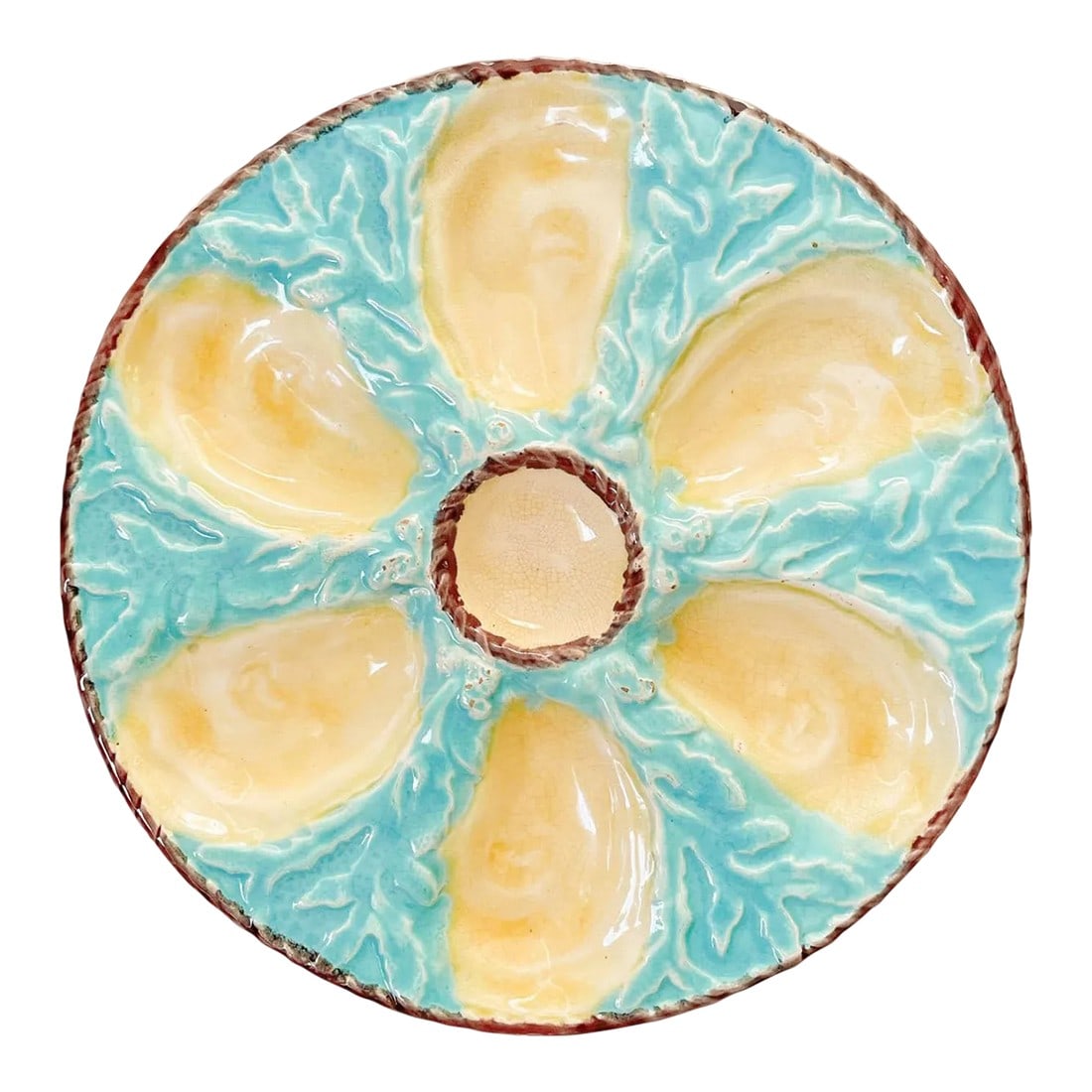 19th Century English Fielding Majolica Oyster Plate: A 19th Century English glazed majolica oyster plate with six cream oyster wells surrounding a center well for sauce and with light turquoise blue ground with seaweed relief. A light brown nautical