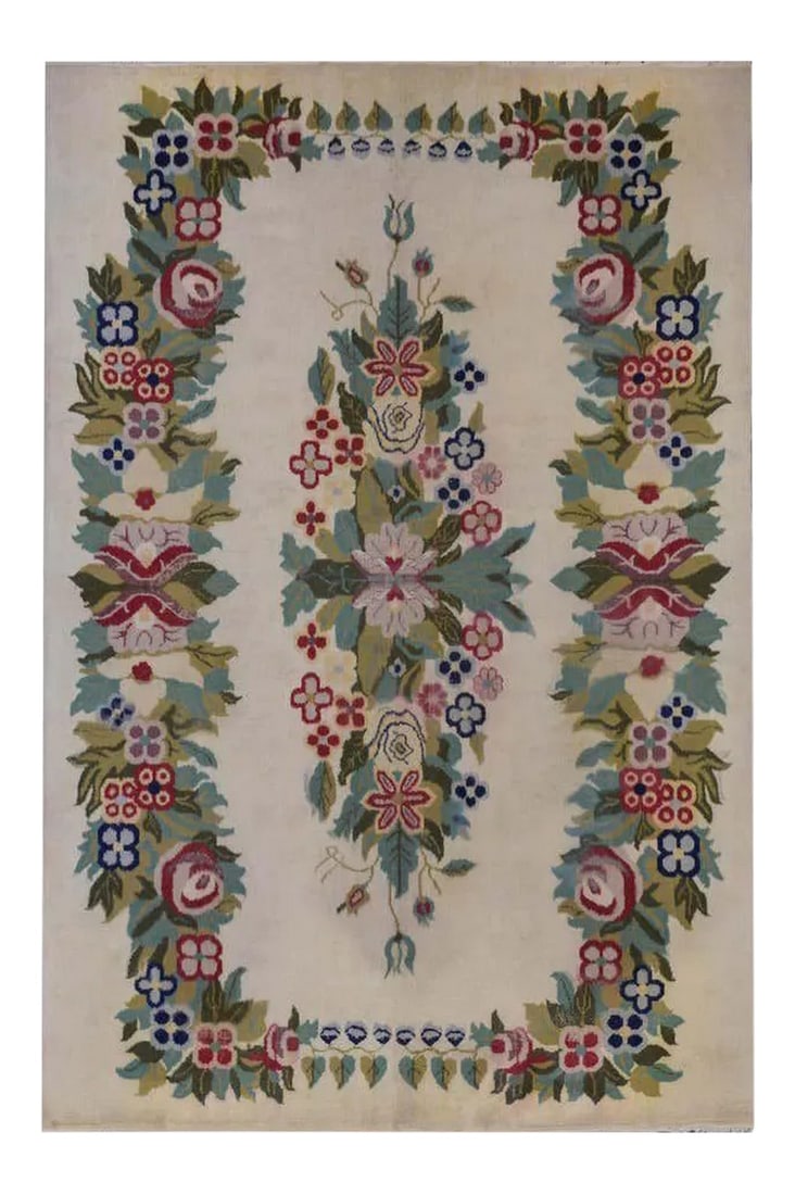 Vintage Chinese Style Rug: An unusual vintage Indian rug woven with a Chinese Art Deco style pattern containing bouquets of flowers woven in various shades of green, pink, cranberry, and light and dark indigo colored wool,