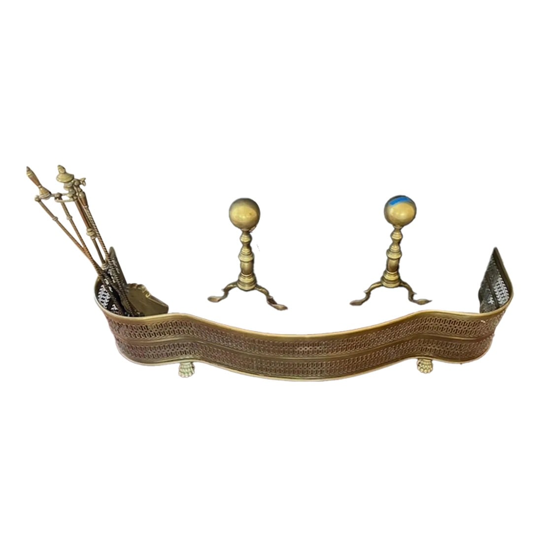 Mid"‘Century Brass Pierced Fireplace Fender + Andirons & Tool Set- 6 Pieces: Elevate your hearth with this mid-century brass fireplace ensemble, masterfully crafted for both beauty and function. The gracefully curved pierced brass fender boasts intricate fretwork and stands
