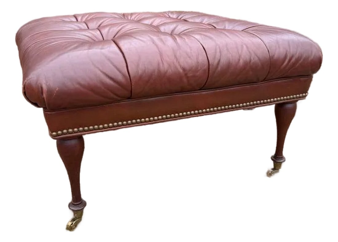 Leather Tufted Ottoman by Charles Stewart: Old school charm at its best! This classic, tufted, oxblood leather ottoman elevates any space with nailhead trim and casters. Made by to-the-trade only Charles Stewart, the quality of this piece is