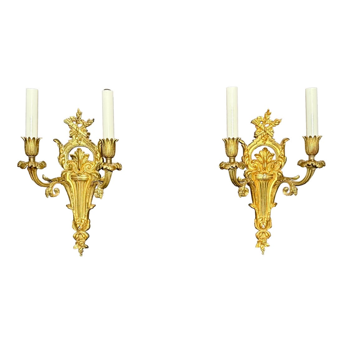 Early 20th Century Pair of Louis XVI Style Gilt Bronze Two Arm Wall Sconces: A refined pair of early 20th century French gilt bronze wall sconces in the Louis XVI style, distinguished by their classical neoclassical ornamentation. Each sconce is surmounted by a sculptural quiv