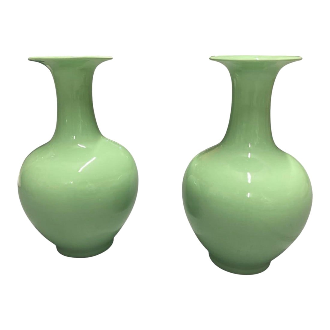 A Pair of Mid-Century Modern Style Porcelain Vases: This elegant pair of mid-century modern style porcelain vases showcases a striking monochromatic celadon green glaze with a high-gloss finish that beautifully catches the light. Each vase features a