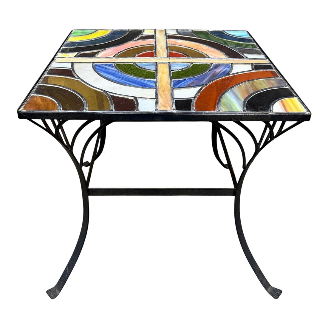 Vintage Stained Glass Side Table Wrought Iron Base Geometric Top: A striking vintage side table featuring a colorful stained glass top set within a sculptural wrought iron base. The geometric glass design showcases rich tones of amber, blue, green, and red arranged